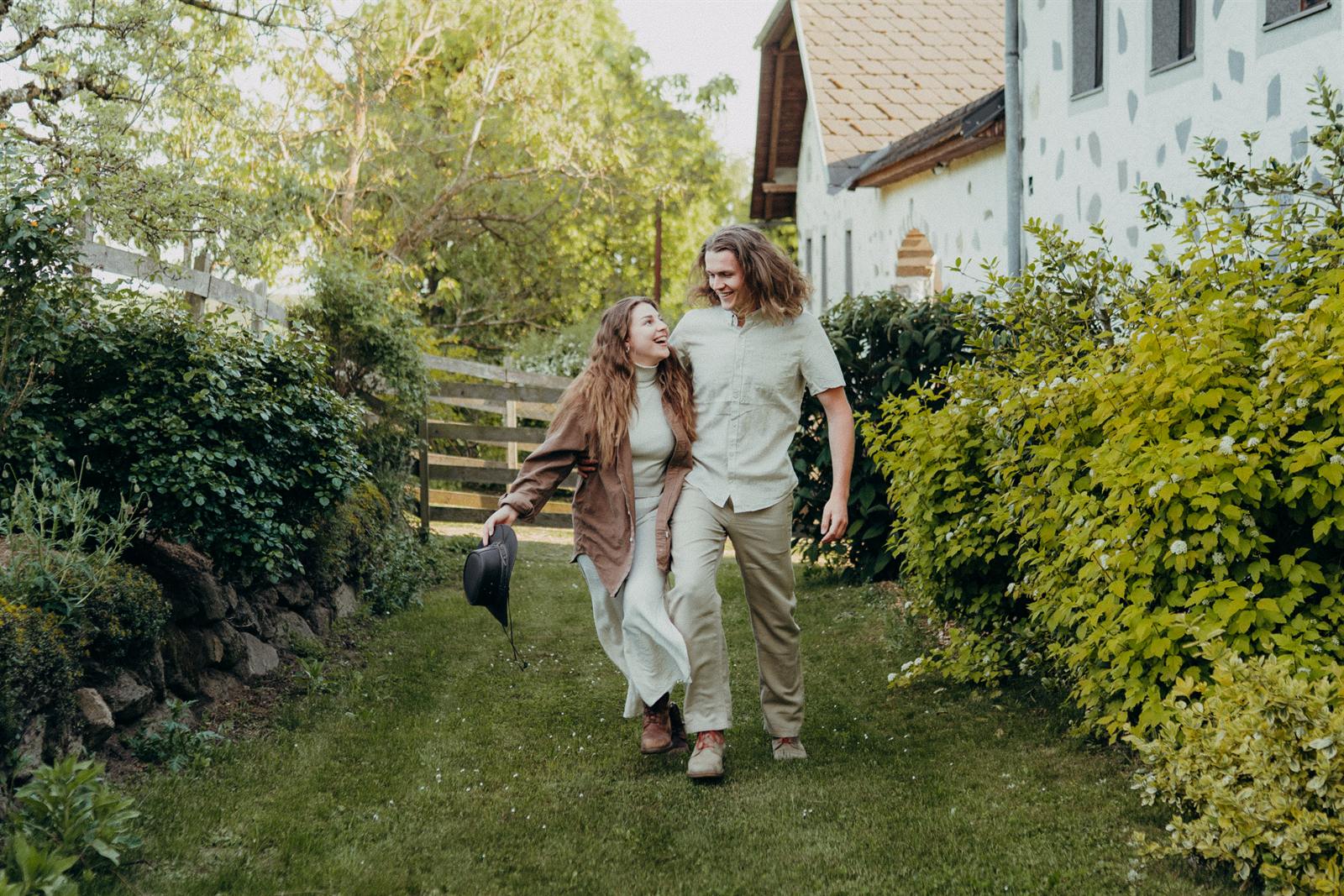 Joe und Alina gehen Arm in Arm durch ihren Garten in Gramastetten