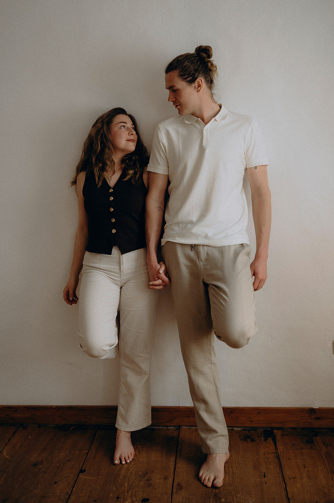 Joe und Alina von Datenstadl, Hand in Hand vor einer hellen Wand