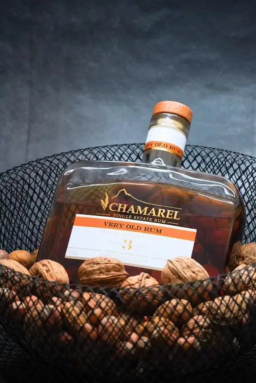 Rumflasche in einem Drahtkorb mit Walnüssen