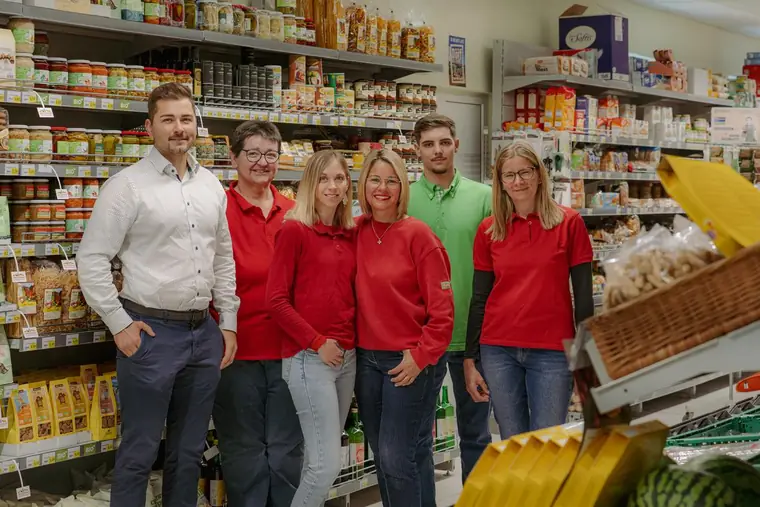 Team in roten Shirts im eigenen Geschäft