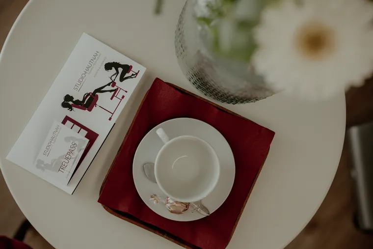 Gedeckter Empfangstisch mit Kaffeetasse und Blumen im Studio